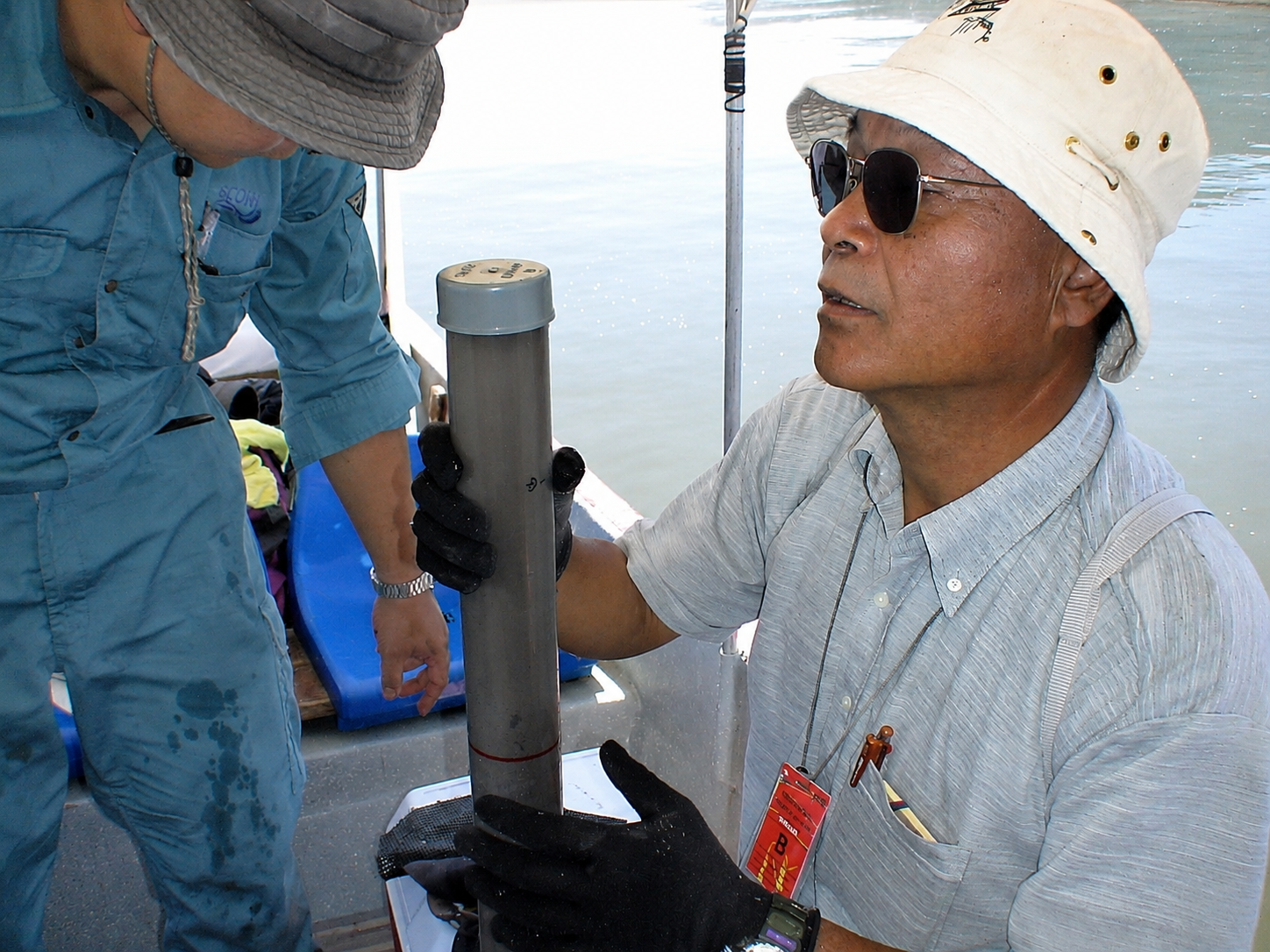Marine specialist examining a cylindrical seabed sample during field analysis